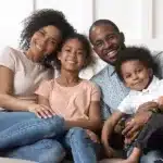 family sitting on couch smiling 1